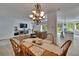 Open-concept dining room with chandelier, wood table and great natural light throughout at 10515 Canary Isle Dr, Tampa, FL 33647
