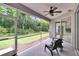 Cozy screened porch with comfortable seating, a ceiling fan, and peaceful outdoor view at 10515 Canary Isle Dr, Tampa, FL 33647