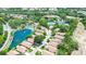 Aerial image showcases a community with lovely lake, tennis courts, pool, and lush green spaces, with house marked by an arrow at 11121 Cherrywood Ct, Spring Hill, FL 34609