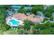 Aerial view of a clubhouse with a pool, shuffleboard court, and tennis courts at 11121 Cherrywood Ct, Spring Hill, FL 34609
