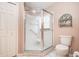 Bathroom with glass enclosed shower, toilet, and neutral walls at 11121 Cherrywood Ct, Spring Hill, FL 34609