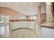 Bright kitchen featuring white cabinetry, tiled floors, breakfast bar, and seamless connection to the sunny outdoor space at 11121 Cherrywood Ct, Spring Hill, FL 34609