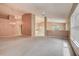 Expansive living room features neutral walls, carpet, ceiling fan and seamless connection to kitchen and dining areas at 11121 Cherrywood Ct, Spring Hill, FL 34609