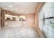 Bright open-concept living room featuring tile floors, ceiling fan, and abundant natural light at 11121 Cherrywood Ct, Spring Hill, FL 34609