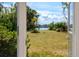 Picturesque backyard view with lush greenery, palm trees, and a tranquil canal in the distance, showcasing waterfront charm at 11465 7Th E St, Treasure Island, FL 33706