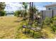 Backyard showing metal chairs on lawn, with canal view featuring a blue sky with fluffy white clouds in the background at 11465 7Th E St, Treasure Island, FL 33706
