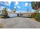Charming single-story home featuring an attached two-car garage and a well-maintained front yard with mature trees at 11465 7Th E St, Treasure Island, FL 33706