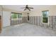 Room featuring a ceiling fan, multiple windows providing natural light, and partially exposed concrete block and wall structure at 11465 7Th E St, Treasure Island, FL 33706
