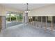 Living room with sliding glass doors leading to a sunroom, unfinished walls, and neutral tones at 11465 7Th E St, Treasure Island, FL 33706