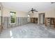 Spacious room featuring a ceiling fan, large windows and partially exposed wall structure, providing natural light at 11465 7Th E St, Treasure Island, FL 33706