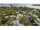 Aerial view of a waterfront property with private dock, pool, lush greenery, and neighborhood at 12 Bayou Ln, Palm Harbor, FL 34683