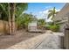 Spacious backyard featuring a charming deck, lush palm trees, a brick path, and privacy fence at 12 Bayou Ln, Palm Harbor, FL 34683