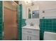 Retro bathroom featuring green tile, a white vanity, and walk-in shower at 12 Bayou Ln, Palm Harbor, FL 34683