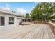 Spacious wooden deck with built-in bench, views of the screened patio, and lush greenery at 12 Bayou Ln, Palm Harbor, FL 34683