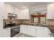 Well-lit kitchen featuring modern stainless steel appliances, stylish countertops, and white cabinetry at 12 Bayou Ln, Palm Harbor, FL 34683