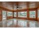 Spacious living room with wood walls, tile floor, and abundant natural light from many windows at 12 Bayou Ln, Palm Harbor, FL 34683