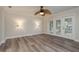Cozy living room featuring wood floors, double doors leading outside, and stylish wall sconces at 12 Bayou Ln, Palm Harbor, FL 34683