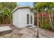 Backyard featuring a private shed with double doors, enhanced by tropical foliage and a tranquil setting at 12 Bayou Ln, Palm Harbor, FL 34683