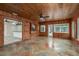 Warm sunroom featuring wood paneling, and views into the kitchen and backyard at 12 Bayou Ln, Palm Harbor, FL 34683