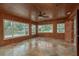 Light-filled sunroom with wood paneling, large windows, and access to the backyard at 12 Bayou Ln, Palm Harbor, FL 34683