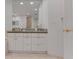 This well-lit bathroom features a granite-topped vanity, a sink, and a large mirror at 1200 Gulf Blvd # 1704, Clearwater Beach, FL 33767