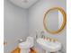 Stylish powder room featuring round mirror, modern fixtures, and wood baseboards at 1200 Gulf Blvd # 1704, Clearwater Beach, FL 33767