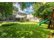 Spacious backyard featuring synthetic turf, a trampoline, playset and partially shaded seating area at 12208 Mcmullen Loop, Riverview, FL 33569