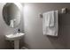 Powder room featuring a pedestal sink, oval mirror, and wall-mounted towel rack at 12208 Mcmullen Loop, Riverview, FL 33569