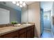Bright bathroom features a spacious vanity with granite countertop, and a shower with elegant curtain at 12208 Mcmullen Loop, Riverview, FL 33569