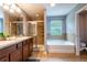 Primary bathroom featuring double sinks, a shower and a separate soaking tub at 12208 Mcmullen Loop, Riverview, FL 33569