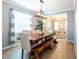 Bright dining room features a modern light fixture and large wooden dining table and bench at 12208 Mcmullen Loop, Riverview, FL 33569