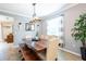 Bright dining room features a modern light fixture and large wooden dining table and bench at 12208 Mcmullen Loop, Riverview, FL 33569