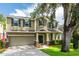 Two story house with an attached garage, a manicured front yard, and mature landscaping at 12208 Mcmullen Loop, Riverview, FL 33569