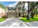 Charming two-story home with an attached two-car garage, well-manicured lawn, and mature tree at 12208 Mcmullen Loop, Riverview, FL 33569