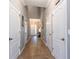Long hallway showcasing neutral walls, tile flooring, and multiple doorways leading to various rooms at 12208 Mcmullen Loop, Riverview, FL 33569