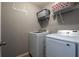 Practical laundry room featuring modern machines and shelving, designed for efficient laundry tasks at 12208 Mcmullen Loop, Riverview, FL 33569