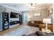 Comfortable living room with neutral tones, ceiling fan, bookshelves, large windows, and stylish decor at 12208 Mcmullen Loop, Riverview, FL 33569