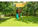 Backyard with a wooden playset featuring a slide, swings, climbing wall, and shaded area at 12208 Mcmullen Loop, Riverview, FL 33569