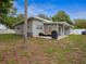 Exterior view of home's backyard, with mature trees and patio at 1242 74Th N St, St Petersburg, FL 33710