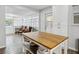 Bright kitchen with a wooden island, white cabinets, and a view into the light-filled living room at 1242 74Th N St, St Petersburg, FL 33710