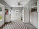 Light-filled sunroom with gray walls, diamond-patterned rug, refrigerator, and access to backyard at 1242 74Th N St, St Petersburg, FL 33710