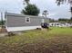 Exterior of the house with a gray facade and a small deck with stairs at 12426 Terra Ceia Ave, New Port Richey, FL 34654