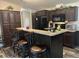 Cozy kitchen features dark cabinetry, breakfast bar with seating, and black appliances at 12426 Terra Ceia Ave, New Port Richey, FL 34654