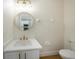 Modern half bathroom with a round mirror and a quartz countertop at 12437 Foxmoor Peak Dr, Riverview, FL 33579