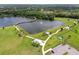 Aerial view showcasing the lake with a curved bridge, walking paths, and a fitness park at 13612 S Village Dr # 5201, Tampa, FL 33618