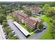 Wide aerial shot of the condo community featuring mature landscaping, a pond, and covered parking at 13612 S Village Dr # 5201, Tampa, FL 33618