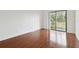 Bright bedroom featuring wood floors and sliding glass doors to balcony at 13612 S Village Dr # 5201, Tampa, FL 33618