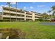 Lovely view of the multi-story condo building with lush green lawn, trimmed hedges, and tall palm trees at 13612 S Village Dr # 5201, Tampa, FL 33618