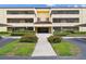 Condo building exterior with well-maintained landscaping, sidewalks, and covered parking at 13612 S Village Dr # 5201, Tampa, FL 33618