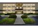 Well-maintained condo building with inviting entrance, landscaping, and covered parking at dusk at 13612 S Village Dr # 5201, Tampa, FL 33618